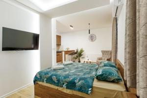 a bedroom with a bed with a blue comforter at Aqua Apartments 1 in Jagodina