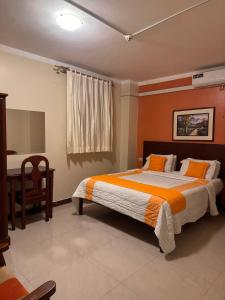 a bedroom with a large bed and a desk at Sol Del Sur Hotel in Huaquillas