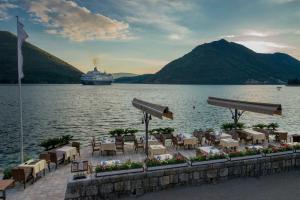 a cruise ship on the water with tables and chairs at Holiday Home Stone House in Perast