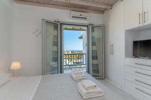 a white bedroom with two towels on a bed at Villa blaue Welle in Kalo Livadi +42 photos