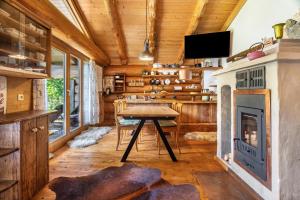 a living room with a table and a fireplace at Chalet 4 in Sankt Englmar