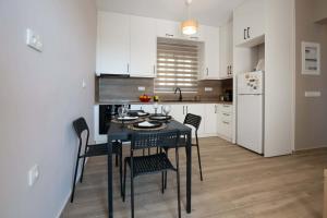 a kitchen with a black table and chairs and a refrigerator at Amfithea Guest House in Amfithea