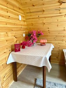 a table in a wooden room with flowers on it at Beshik Guest House in Bokonbayevo
