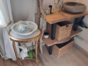 a table with a bowl on it next to a shelf with baskets at La Parenthese in Folles
