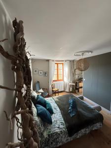 a bedroom with a large bed with blue pillows at La Parenthese in Folles