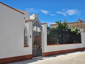 a white fence with a black gate at Teseo Holiday in Castelvetrano Selinunte