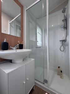 a white bathroom with a sink and a shower at Coastal Escape in Heysham +36 photos