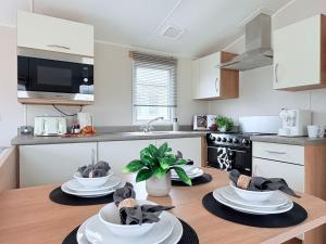 a kitchen with three plates on a wooden table at Coastal Escape in Heysham