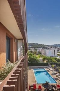 a balcony of a building with a swimming pool at Résidence Odalys Terra Gaia in Sète
