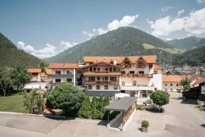 a large building with a mountain in the background at Hotel Traube in Pfunds