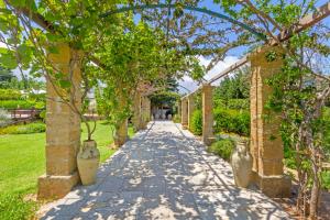 a walkway in a garden with vases on it at Masseria L'Uliveto Agri Resort in Otranto