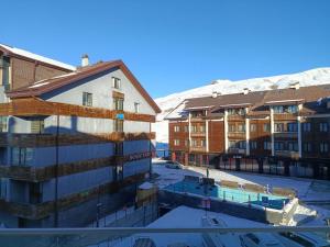 a group of buildings with snow covered mountains in the background at New Gudauri Rooms in Gudauri