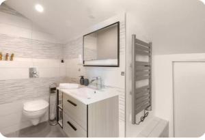 a white bathroom with a sink and a toilet at Chambre premium PLUME - jardin - 2p in Sainte-Geneviève-des-Bois