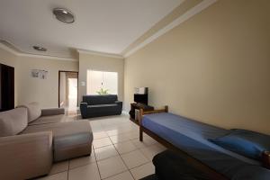 a living room with a bed and a couch at Campo Grande Guest Flat in Campo Grande
