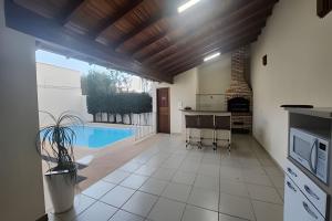 a kitchen with a swimming pool and a kitchen with a stove at Campo Grande Guest Flat in Campo Grande