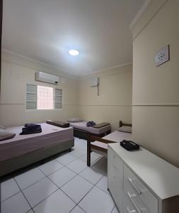 a room with three beds in a room with at Campo Grande Guest Flat in Campo Grande +27 photos