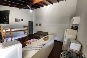 a kitchen with a counter and a living room at Dourados Guest Flat, your choice in Dourados-MS. in Dourados