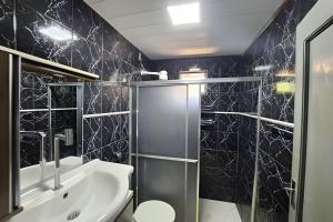 a bathroom with a sink and a shower at Dourados Guest Flat, your choice in Dourados-MS. in Dourados +11 photos