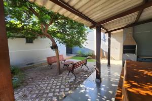 a patio with two benches and a tree at Dourados Guest Flat, your choice in Dourados-MS. in Dourados