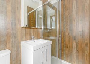 a bathroom with a white sink and a shower at Talacre Beach Resort in Talacre