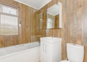a bathroom with a toilet and a sink and a mirror at Talacre Beach Resort in Talacre +228 photos