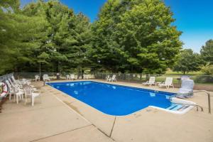 a swimming pool with tables and chairs and trees at Legends Fountain View Ground Floor Studio Unit 109 in Bellaire
