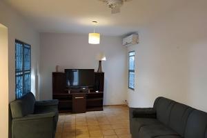 a living room with two couches and a tv at Dourados Guest Flat House in Dourados