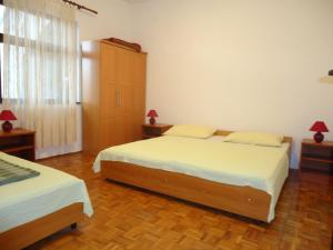 ein Schlafzimmer mit zwei Betten und einem großen Fenster in der Unterkunft Apartments Vrša in Seline