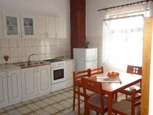 eine Küche mit Tisch, Spüle und Herd in der Unterkunft Apartments Vrša in Seline