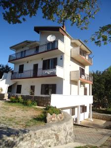 ein großes weißes Gebäude mit einer Uhr darauf in der Unterkunft Apartments Vrša in Seline