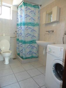 ein Badezimmer mit einem Duschvorhang mit Fischen darauf in der Unterkunft Apartments Vrša in Seline