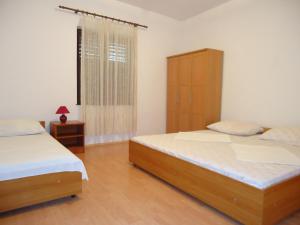 1 Schlafzimmer mit 2 Betten, einem Schrank und einem Fenster in der Unterkunft Apartments Vrša in Seline