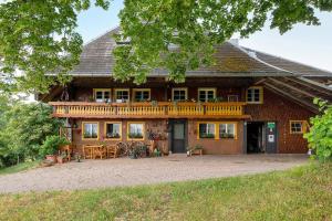 a large house with a balcony and a patio at Reesbauernhof - Fewo Abendrot in Oberried