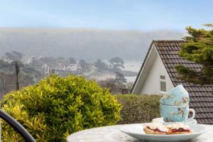 a table with a plate of food and a cup on it at Summers Beach View in Saint Mawes