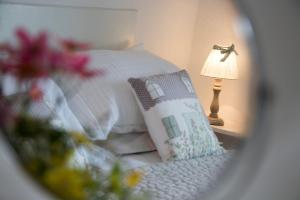 a bedroom with a bed with a lamp and a pillow at Summers Beach View in Saint Mawes