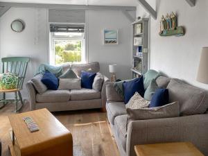 a living room with two couches and a table at Summers Beach View in Saint Mawes