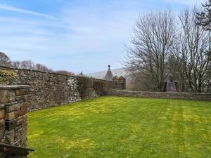 a stone wall with a green lawn in front of it at West House - Uk51668 in Leyburn