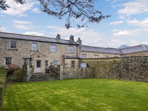 an exterior view of a stone house with a large yard at West House - Uk51668 in Leyburn