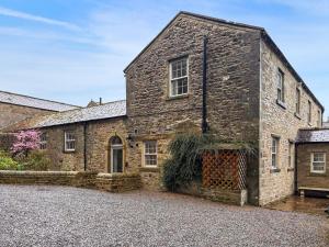 an old stone building with a gate in front of it at West House - Uk51668 in Leyburn