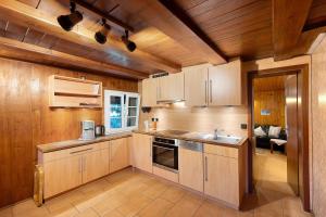 a kitchen with wooden cabinets and a sink at Reesbauernhof - Fewo Abendrot in Oberried