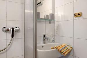 a white bathroom with a sink and a shower at Reesbauernhof - Fewo Abendrot in Oberried