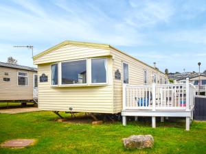 a yellow tiny house with a white porch at Beech Walk 45 - Ukc9406 in Exmouth