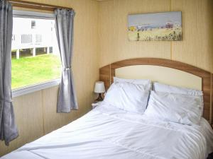 a bedroom with a white bed with a window at Beech Walk 45 - Ukc9406 in Exmouth +4 photos