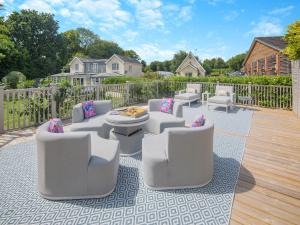 a patio with white furniture on a wooden deck at Woodlea Farm in Four Marks