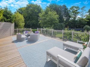 a patio with couches and chairs on a wooden deck at Woodlea Farm in Four Marks