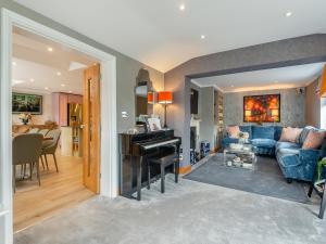 a living room with a blue couch and a piano at Woodlea Farm in Four Marks