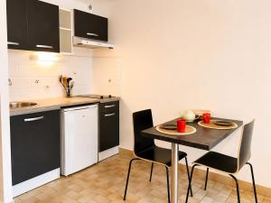 a small kitchen with a table and chairs in a room at Studio centre-ville avec ascenseur - Le Mistral in Digne-les-Bains