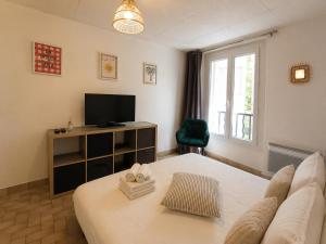 a bedroom with a bed and a tv and a window at Studio centre-ville avec ascenseur - Le Mistral in Digne-les-Bains