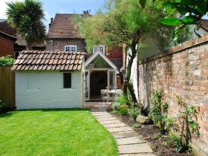 a yard with a brick wall and a house at Pemberly in Winchester