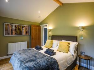a bedroom with a large bed with yellow pillows at Lakeside Lodge - Uk50627 in Welshpool +13 photos
